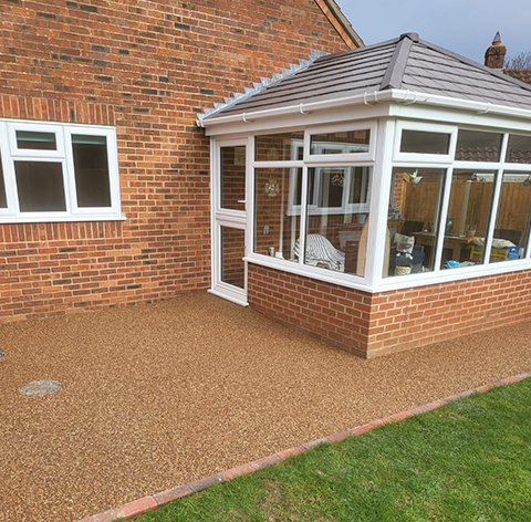 a conservatory build with brick and large windows on an extension of a brick house